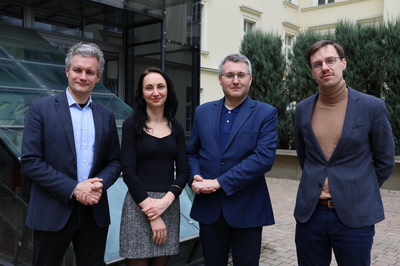 Czworo członków Centrum badawczo-wdrożeniowego Critical Thinking Research Lab stoi na dziedzińcu Uniwersytetu Ignatianum w Krakowie.